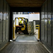 Forklift loading a trailer at a dock