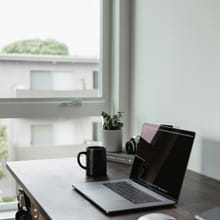 Laptop on a home desk by a window