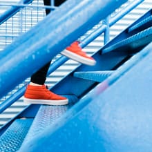 Person climbing bright blue stairs