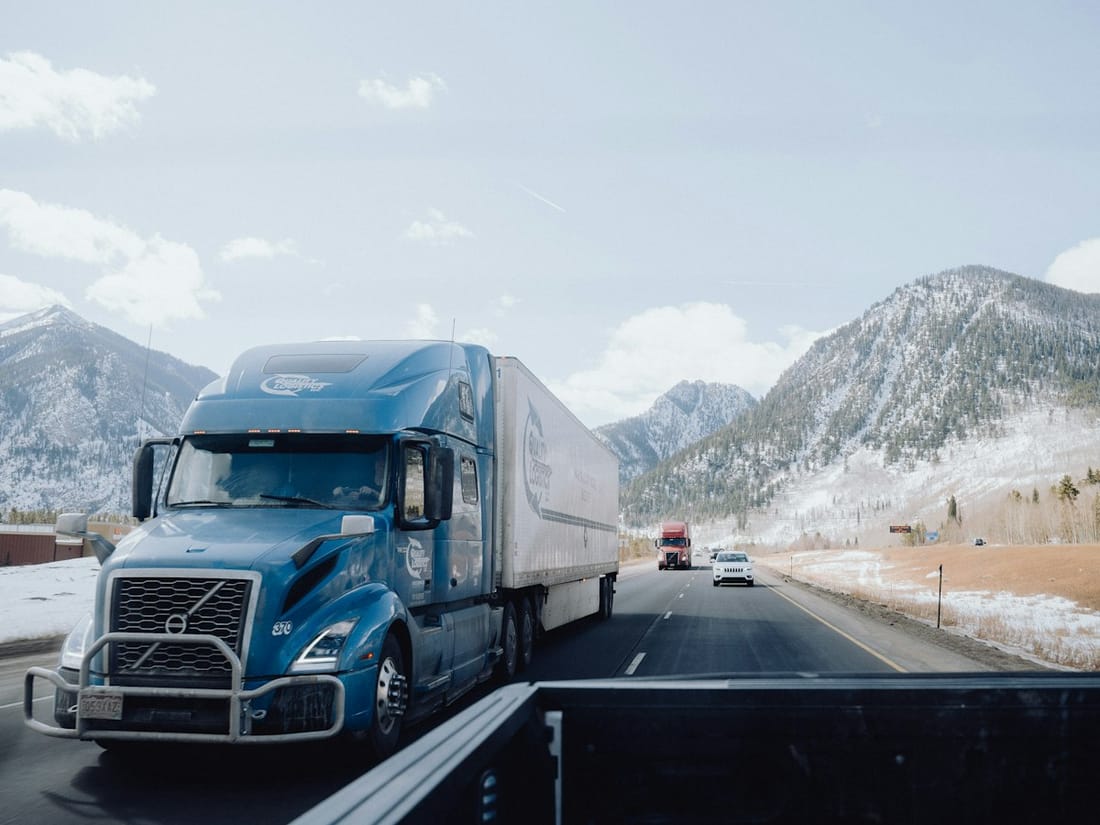 Blue semi truck hauling a trailer on a highway